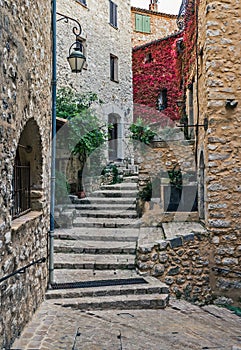 Street with flowers in the old village , France.