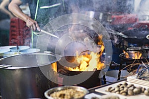 Street food in Bangkok Bangkok Thailand - Oct 24, 2020 :- Chef cooking with fire with frying pan on gas hob