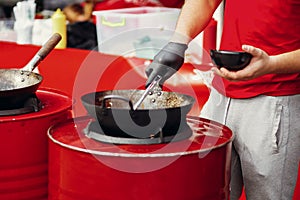 Street food chef cooking noodles and vegetables in a pan on fire at open kitchen. Fried noodles in a wok on the open fire. Asian