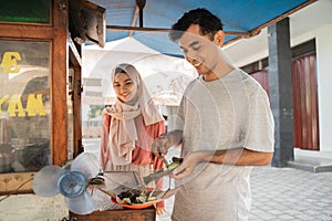 street food seller with walking stall of indonesian Chicken Satay Cooking on a Hot Charcoal Grill