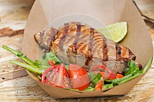 Street food tuna steak served with vegetables closeup