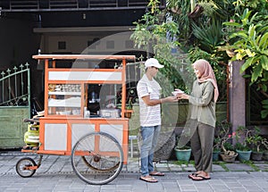 Street food vendor handing a bowl of bakso photo