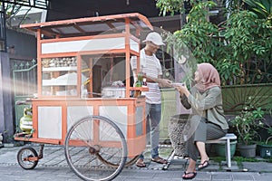 Street food vendor handing a bowl of bakso photo