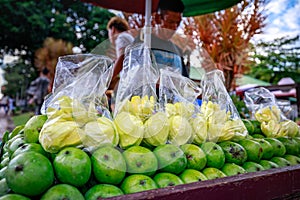 A street food vendor slices fresh green mango which sells on foo