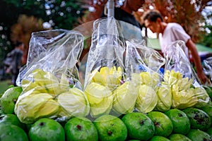 A street food vendor slices fresh green mango which sells on foo