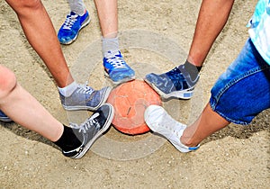 Street football. Boys feet with the ball in the sand