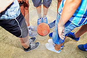 Street football. Boys feet with the ball in the sand