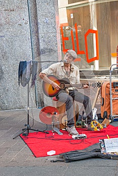 Street guitar player and singer in historical downtown of Milan, Italy