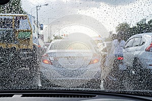 Street in the heavy rain. Water drops or rain in front of mirror of car on road or street