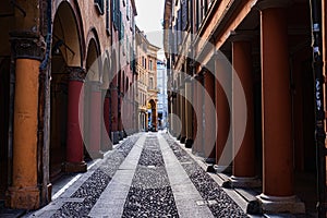 street of the historic center of Bologna by day. arcades, arcades, columns, passers-by, architecture. Italy