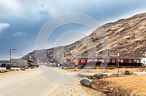 Street in Kangerlussuaq settlement with small living houses among mountains, Greenland