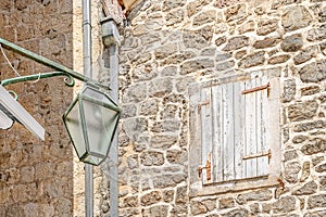 Street lamp against the background of a window with wooden shutters