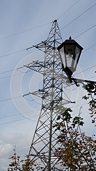 A street lamp on the background of a power line tower with stretched wires.