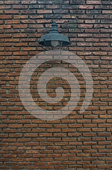 Street lamp hanging on the dirty brick wall background