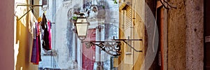Street lamp and laundry in a picturesque narrow street of Alfama in the old town of Lisbon Portugal