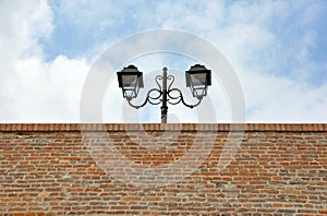 Street lamp over brick wall
