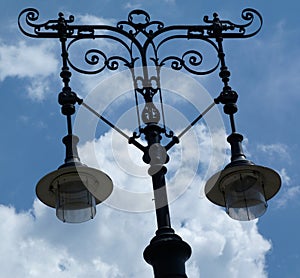 Street lamp pole and light fixtures under blue sky