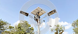 street lamp poles or garden lights with solar power panels, sky background and trees