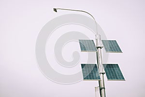 Street lamp poles powered by solar energy. Solar panels on electric pole for lighting on the road in the city on the bridge