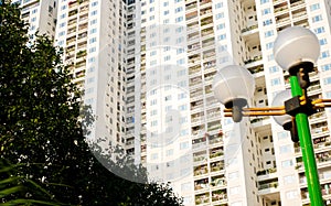 Street lamp post light pole, green street looking up high-rise apartment complex condominium buildings balcony hanging clothes in