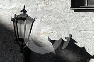 Street lamp with shadow on wall