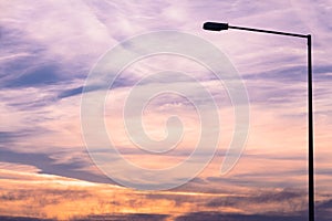 Street lamp silhouette on colorful dawn/dusk sky background.