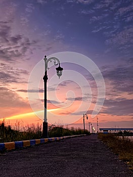 Street lamp silhouette near Setu patok dam when sunrise