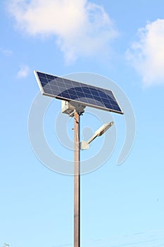 street lamp with a solar battery against a blue sky