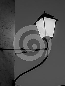 The street lamp on traditional stone wall. Bblack and white photo. photo