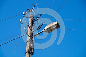 Street lamp with wires against the blue sky photo