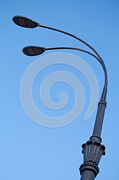 Street lamps aligned with beautiful blue sky in background