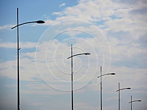 Street lamps aligned under big blue sky