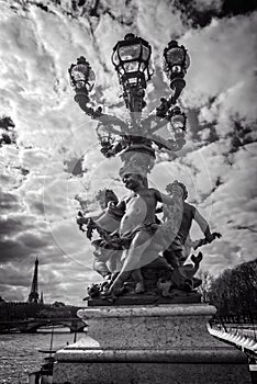 Street lantern from year 1900 on bridge Alexandre III, the river Seine and the Eiffel tower, Paris France, black and white photog