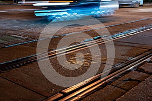 Street level selective focus on trolley rail lines at night in San Diego.