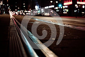 Street level selective focus on trolley rail lines at night in San Diego.