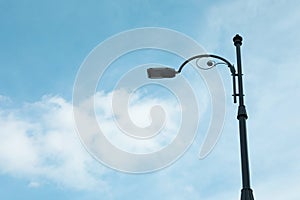 Street light lamp against cloudy sky, space for text