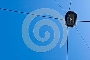 Street light and multiple electrical power lines extending into the distance captured from below