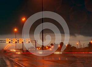 Street light at night in rainy day. Car and truck on asphalt road. Dark night at highway with electric lamp light and speed limit