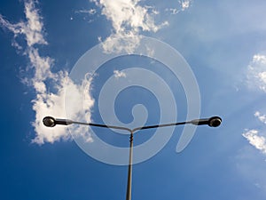 Street light pole on blue sky.