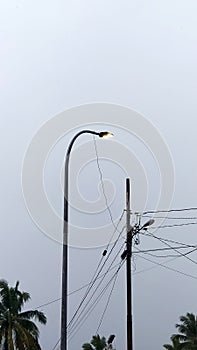 street lights, electricity poles, clouds, and power lines