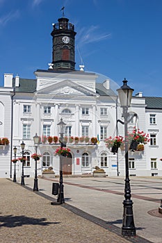 Street lights with flowers in front of the town hall in Plock