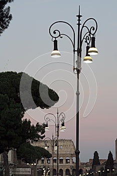 Street lights near colosseum at sunset in Rome Italy.