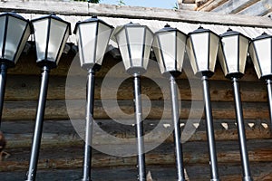 Street lights unconnected near a wooden house