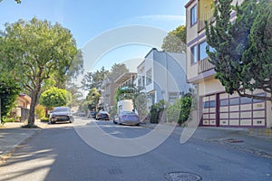 Street in the middle of residential area with parked vehicles in San Francisco, California