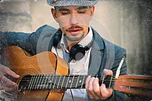 Street music art. Retro styled portrait of young man playing the guitar outdoors in old European city