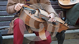 Street musician dressed in vintage ethnic oriental clothes play music on traditional Middle Eastern musical instrument