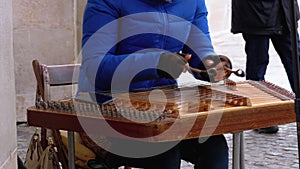 Street musician plays a musical instrument - folk cimbalom