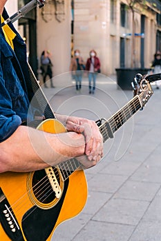 Street musician resting his hands on a guitar