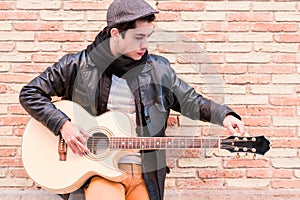 Street musician tuning the guitar. Fingers turning the tuning pegs of an acoustic guitar