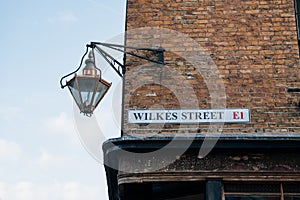 Street name sign on a building on Wilkes Street in London, UK photo